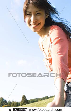 Stock Photo - Woman holding out her hand to the camera. Fotosearch