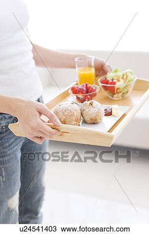 Woman holding tray with a meal of salad, strawberries and bread rolls and a glass of juice View Large Photo Image Stock Image - Woman holding tray with a meal of salad, strawberries and bread rolls and a glass of juice. Fotosearch