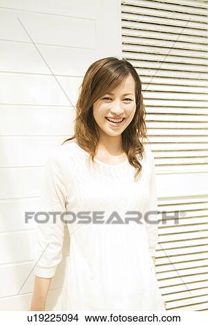 Woman leaning against a wall View Large Photo Image Picture - Woman leaning against a wall. Fotosearch