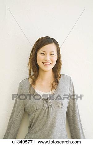 Woman leaning against a wall View Large Photo Image Stock Image - Woman leaning against a wall. Fotosearch