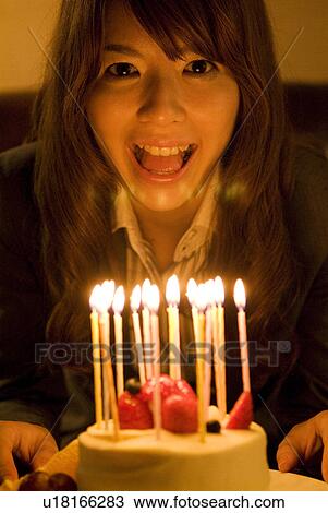 Woman leaning over to blow out the candles on her birthday cake View Large Photo Image Stock Image - Woman leaning over to blow out the candles on her birthday cake. Fotosearch