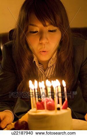 Woman leaning over to blow out the candles on her birthday cake View Large Photo Image Stock Image - Woman leaning over to blow out the candles on her birthday cake. Fotosearch