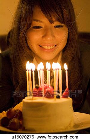 Woman leaning over to blow out the candles on her birthday cake View Large Photo Image Stock Photograph - Woman leaning over to blow out the candles on her birthday cake. Fotosearch