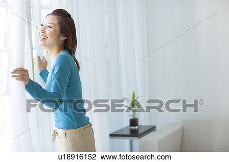 Stock Image - Woman looking out of window. Fotosearch