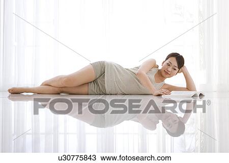 Woman lying down reading book View Large Photo Image Stock Image - Woman lying down reading book. Fotosearch