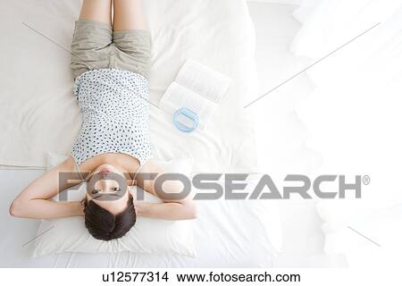 Picture - Woman lying in bed. Fotosearch
