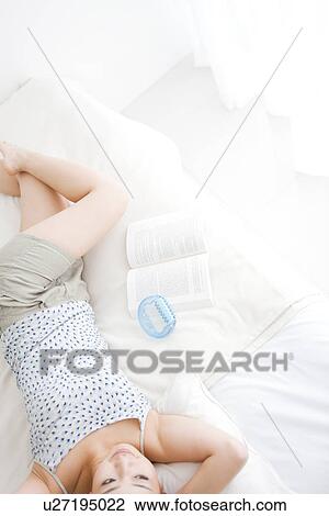 Stock Image - Woman lying in bed. Fotosearch