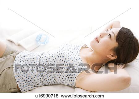 Stock Photo - Woman lying in bed. Fotosearch