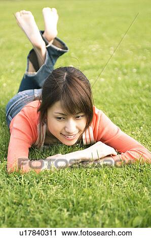 Stock Image - Woman lying on grass. Fotosearch