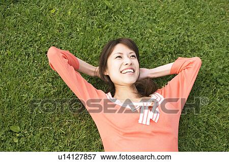 Stock Photo - Woman lying on grass. Fotosearch