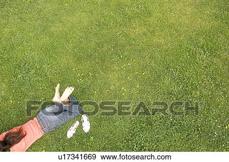 Woman lying on grass View Large Photo Image Stock Photo - Woman lying on grass. Fotosearch