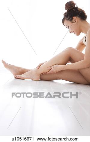 Stock Image - Woman massaging her leg. Fotosearch