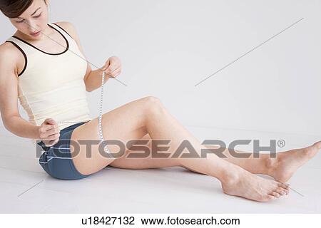 Woman measuring her thigh View Large Photo Image Stock Image - Woman measuring her thigh. Fotosearch