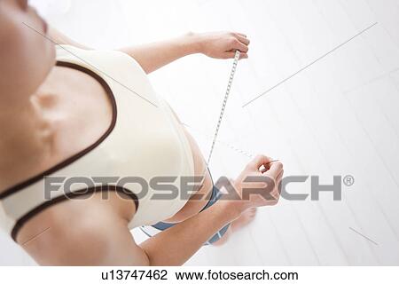 Woman measuring her waist View Large Photo Image Stock Image - Woman measuring her waist. Fotosearch