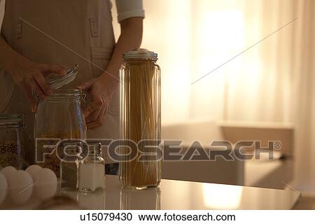 Woman opening jar of pasta View Large Photo Image Stock Image - Woman opening jar of pasta. Fotosearch