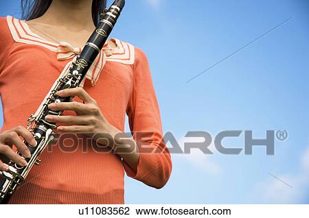 Stock Image - Woman playing a clarinet. Fotosearch