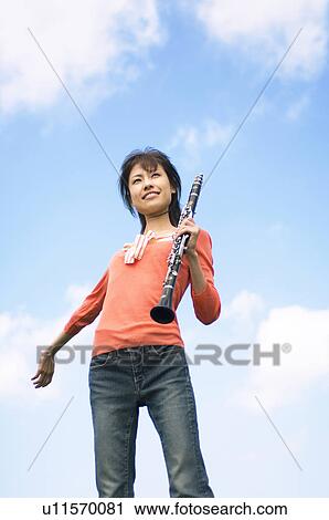 Woman playing a clarinet View Large Photo Image Stock Image - Woman playing a clarinet. Fotosearch