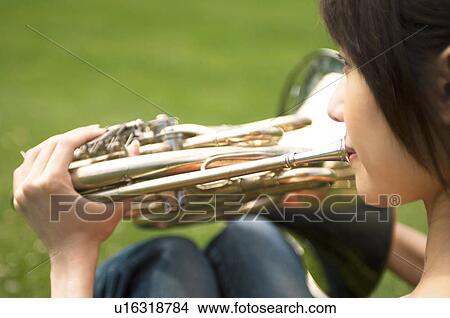 Picture - Woman playing a French horn. Fotosearch