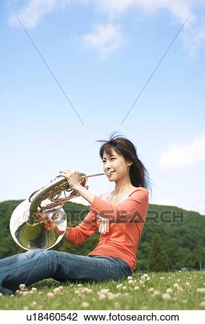 Woman playing a French horn View Large Photo Image Stock Image - Woman playing a French horn. Fotosearch