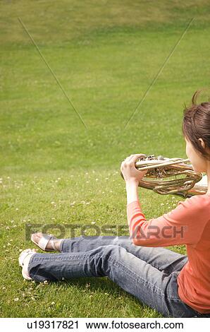 Woman playing a French horn View Large Photo Image Stock Image - Woman playing a French horn. Fotosearch