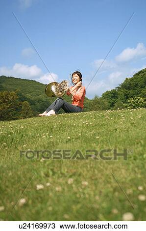Stock Image - Woman playing a French horn. Fotosearch