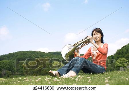 Woman playing a French horn View Large Photo Image Stock Image - Woman playing a French horn. Fotosearch
