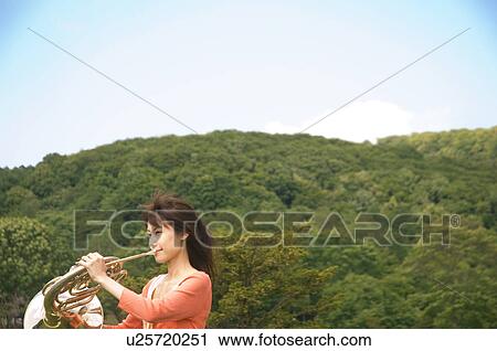 Woman playing a French horn View Large Photo Image Stock Image - Woman playing a French horn. Fotosearch