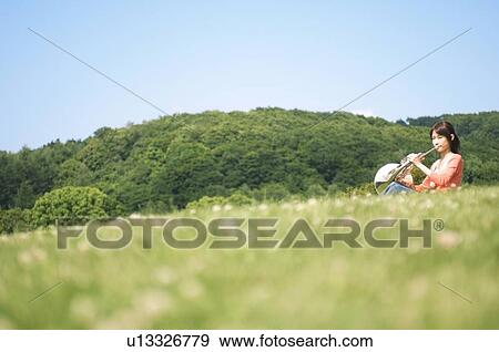 Woman playing a French horn View Large Photo Image Stock Photo - Woman playing a French horn. Fotosearch