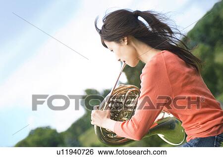 Stock Photograph - Woman playing a French horn. Fotosearch