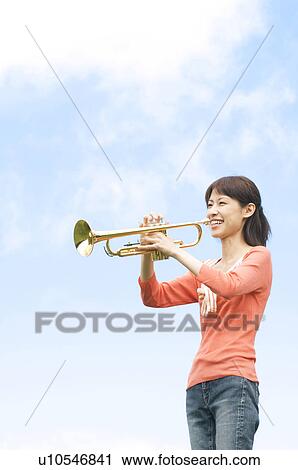 Woman playing a trumpet View Large Photo Image Stock Image - Woman playing a trumpet. Fotosearch