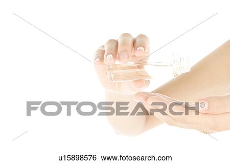 Stock Photograph - Woman pouring oil into palm. Fotosearch