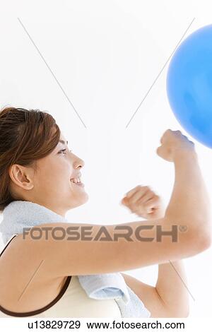 Stock Photo - Woman punching a balloon. Fotosearch