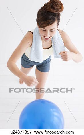 Stock Photo - Woman punching a balloon. Fotosearch