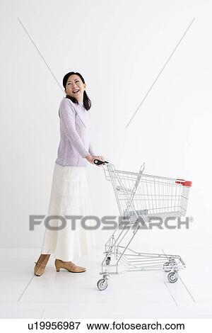 Stock Photo - Woman pushing a shopping cart. Fotosearch