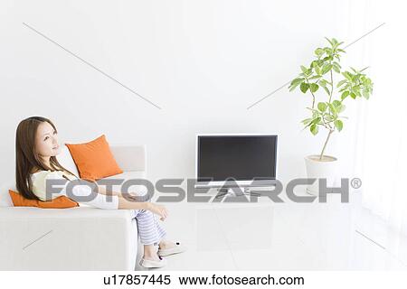 Woman relaxing in living room on sofa View Large Photo Image Stock Photography - Woman relaxing in living room on sofa. Fotosearch