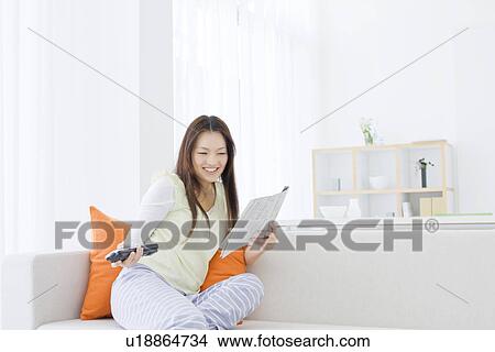 Woman relaxing in living room View Large Photo Image Picture - Woman relaxing in living room. Fotosearch