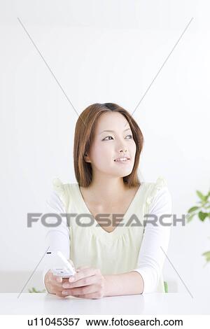 Stock Photo - Woman relaxing in living room. Fotosearch
