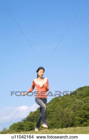 Woman running in a field View Large Photo Image Picture - Woman running in a field. Fotosearch