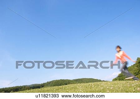 Woman running in a field View Large Photo Image Stock Image - Woman running in a field. Fotosearch