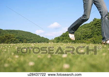 Woman running in a field View Large Photo Image Stock Image - Woman running in a field. Fotosearch