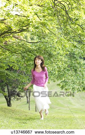 Stock Photo - Woman running in a field. Fotosearch