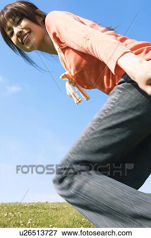 Woman running in a field View Large Photo Image Stock Photo - Woman running in a field. Fotosearch