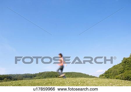 Woman running in a field View Large Photo Image Stock Photograph - Woman running in a field. Fotosearch