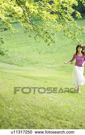 Woman running through a field View Large Photo Image Stock Image - Woman running through a field. Fotosearch