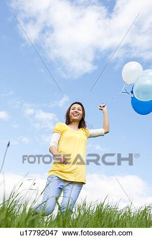 Woman running with balloons View Large Photo Image Stock Photo - Woman running with balloons. Fotosearch