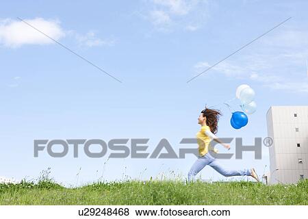 Woman running with balloons View Large Photo Image Stock Photo - Woman running with balloons. Fotosearch