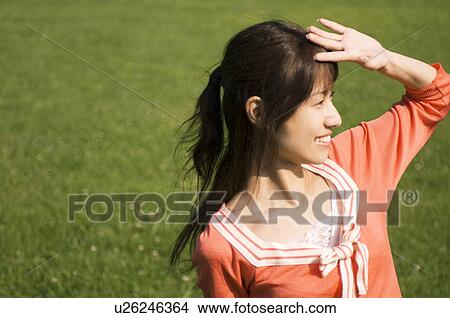 Woman shielding her eyes from the sun View Large Photo Image Picture - Woman shielding her eyes from the sun. Fotosearch