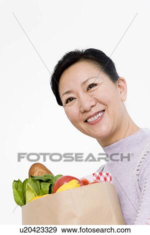 Stock Photo - Woman shopping for groceries. Fotosearch