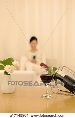 Woman sitting on a sofa using a mobile phone View Large Photo Image Picture - Woman sitting on a sofa using a mobile phone. Fotosearch