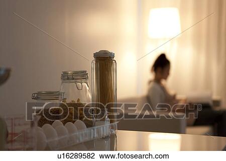 Woman sitting on sofa with ingredients on kitchen counter View Large Photo Image Stock Image - Woman sitting on sofa with ingredients on kitchen counter. Fotosearch